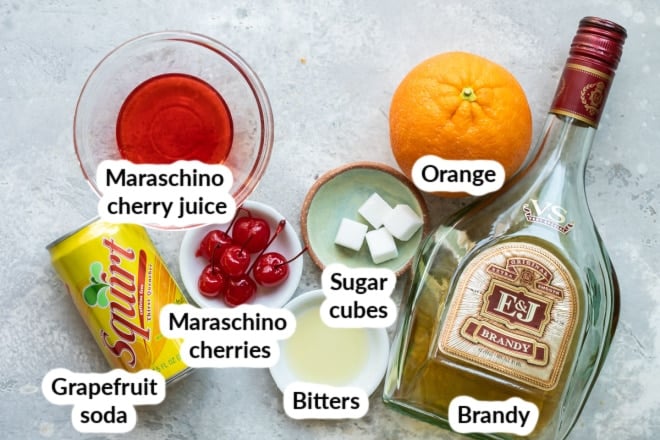 Labeled brandy old fashioned ingredients in bowls and bottles.