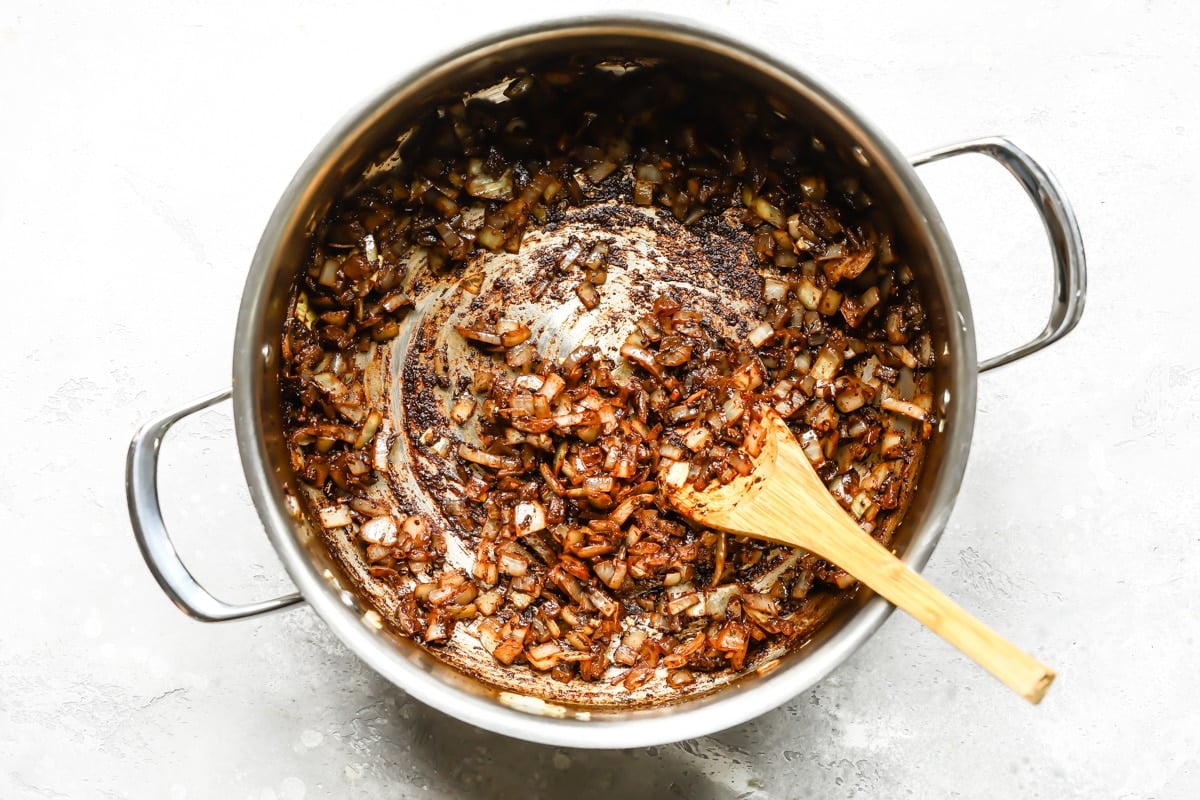 Cincinnati chili ingredients cooking in a silver pot.