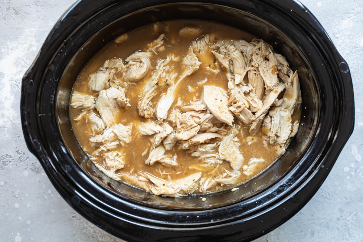 Hot turkey sandwich meat shredded in a slow cooker.