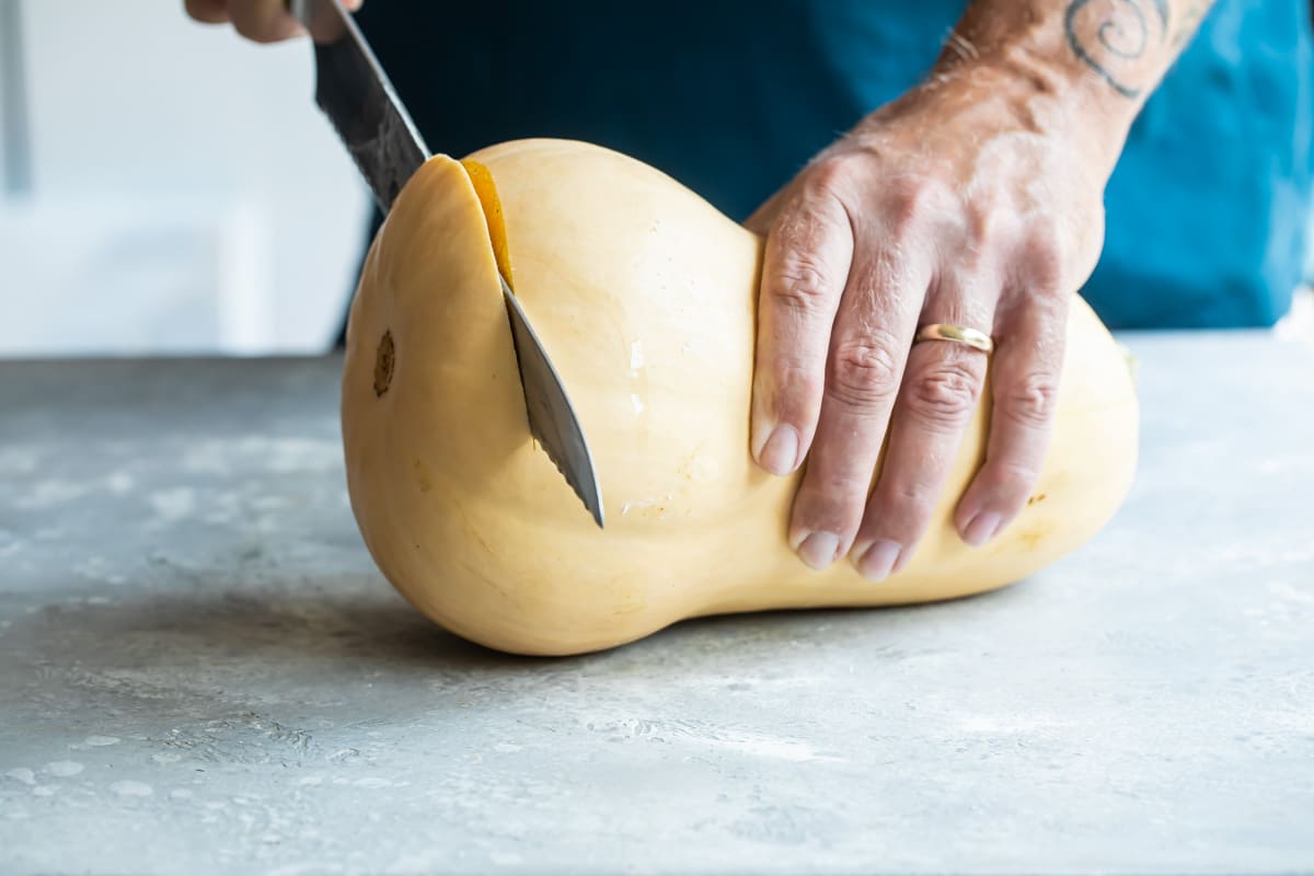 The end being trimmed off a butternut squash.