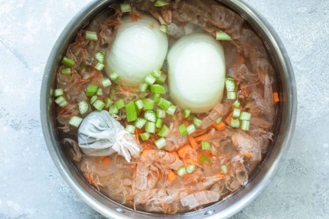 Shrimp stock ingredients in a silver pot.