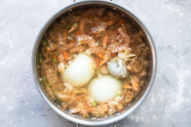 Shrimp stock ingredients in a silver pot.