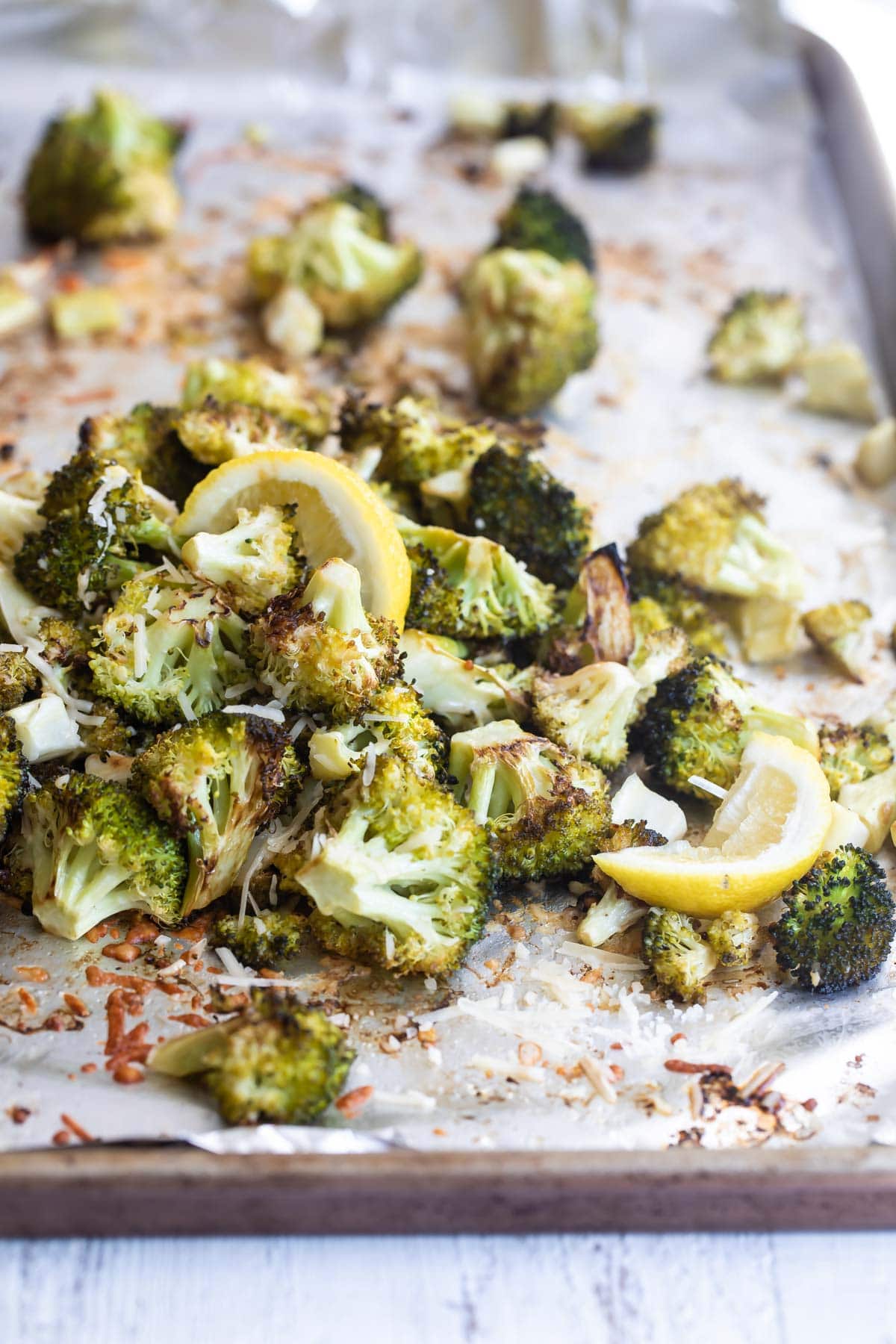 Roasted broccoli with lemon on a baking sheet.