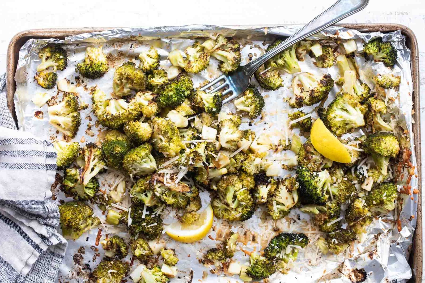 Roasted broccoli with lemon on a baking sheet.