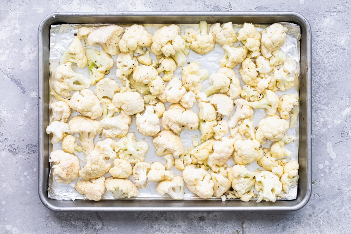 Cauliflower on a baking sheet before roasting.