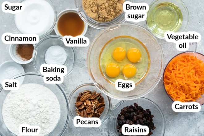 Labeled carrot cake ingredients in various bowls.