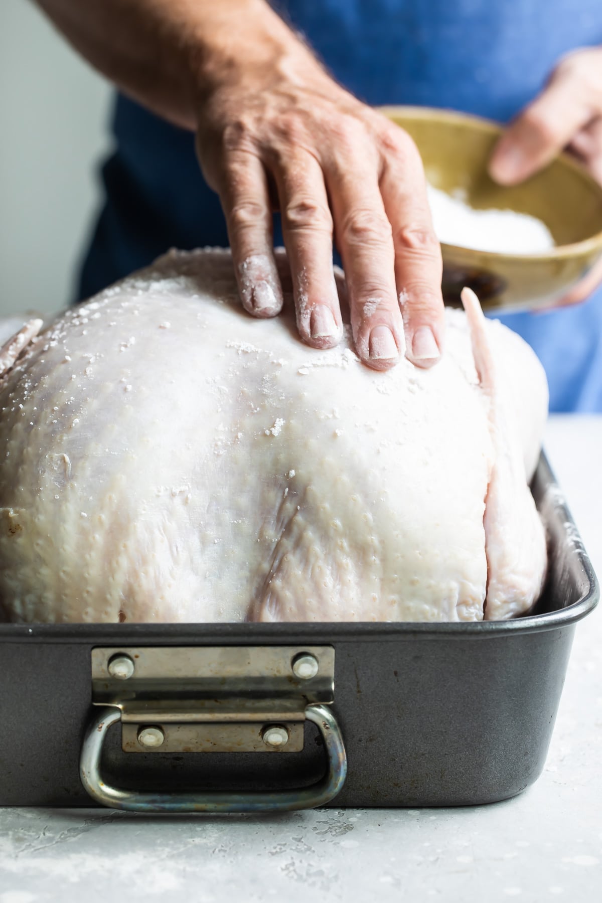 A raw turkey with salt rubbed on it for briniing.