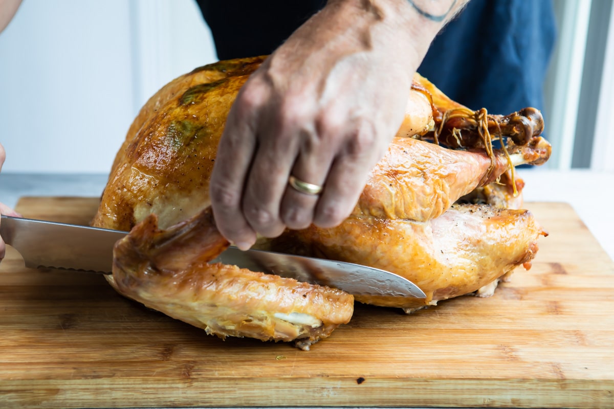 Carving a wing off a roasted turkey.