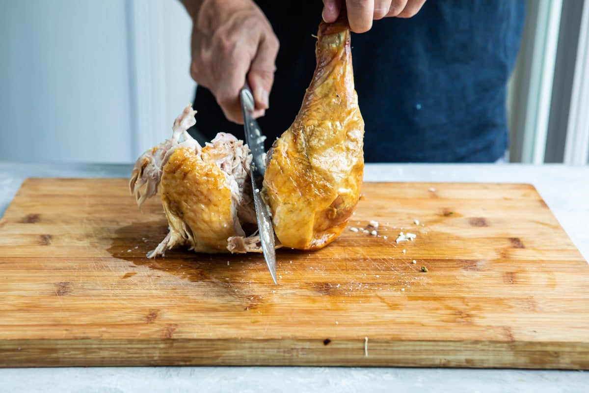 Carving a roasting turkey leg.