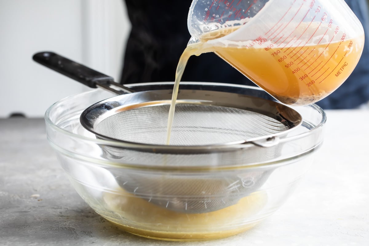 Pouring turkey gravy through a sieve.