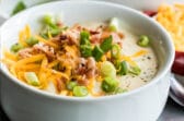 Loaded baked potato soup in a white bowl.