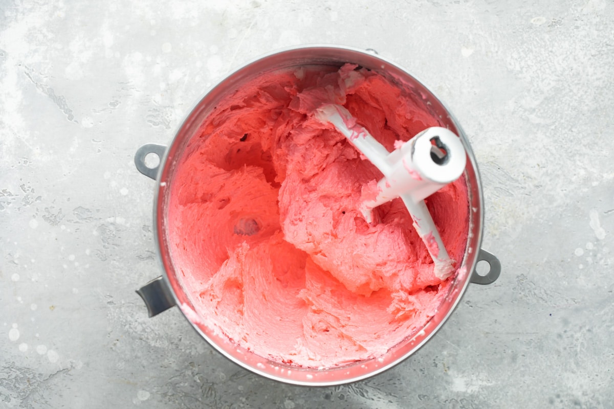 Red velvet cookie dough in a silver mixing bowl.