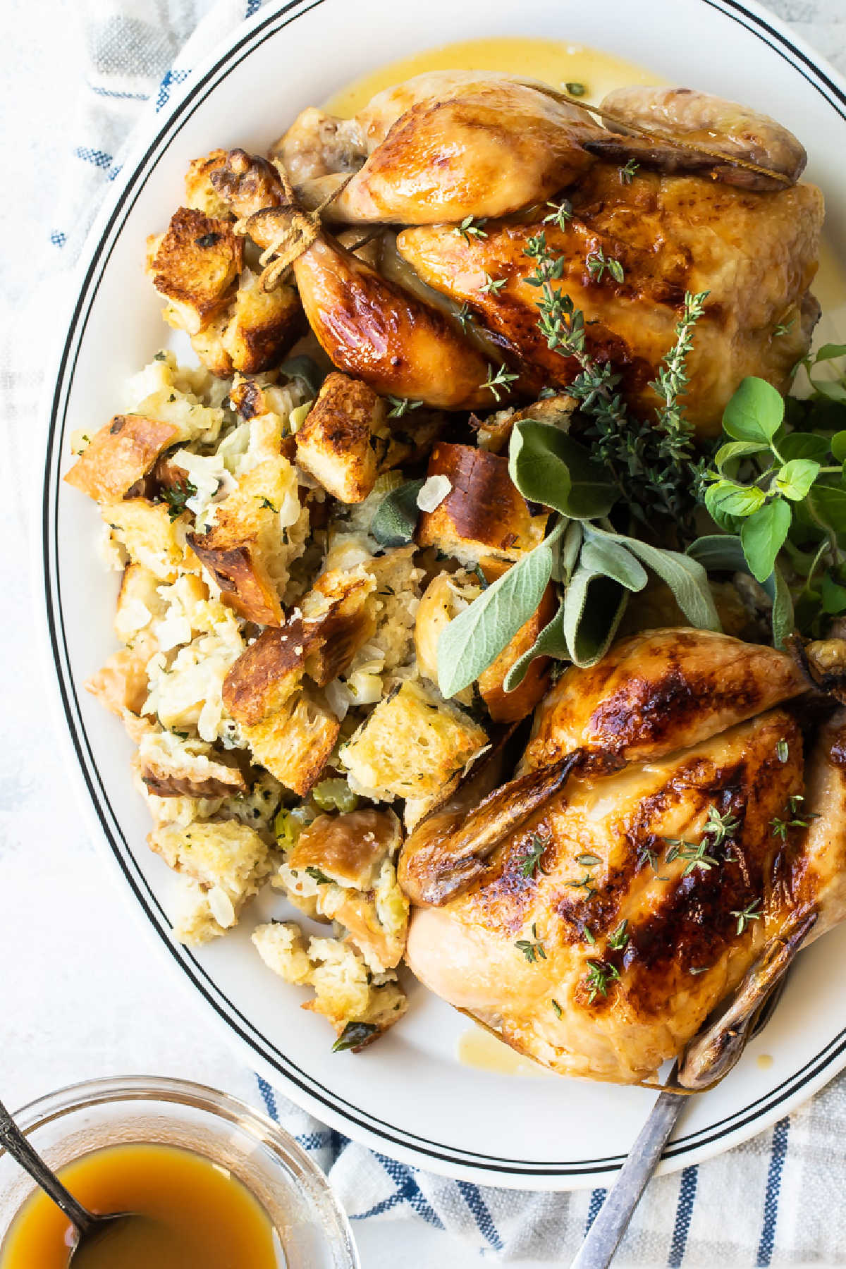Two cornish hens with stuffing on a serving platter.