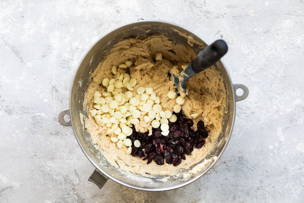 Dough for cranberry cookies with white chocolate in a mixing bowl.