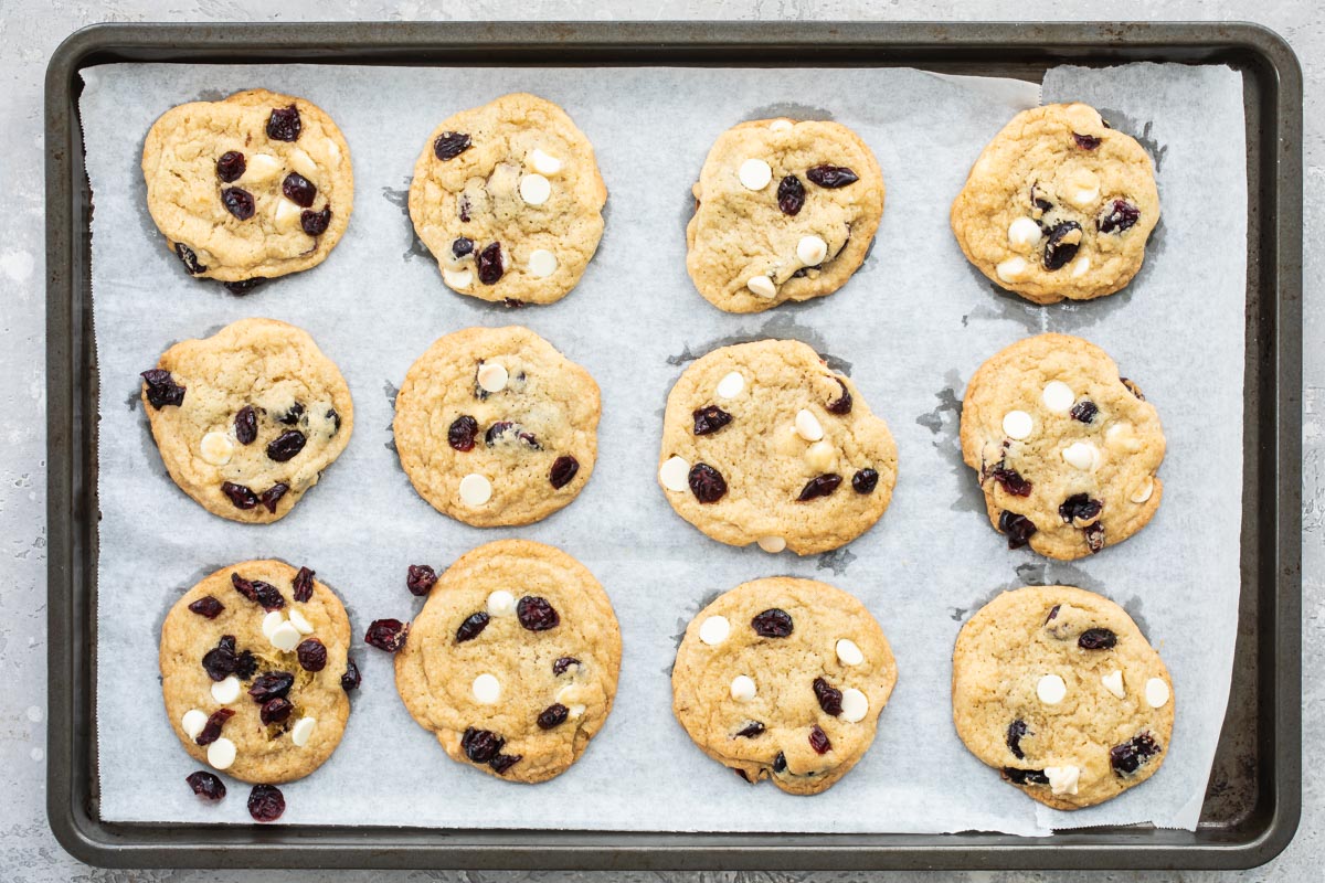 Cranberry cookies with white chocolate on a baking sheet.