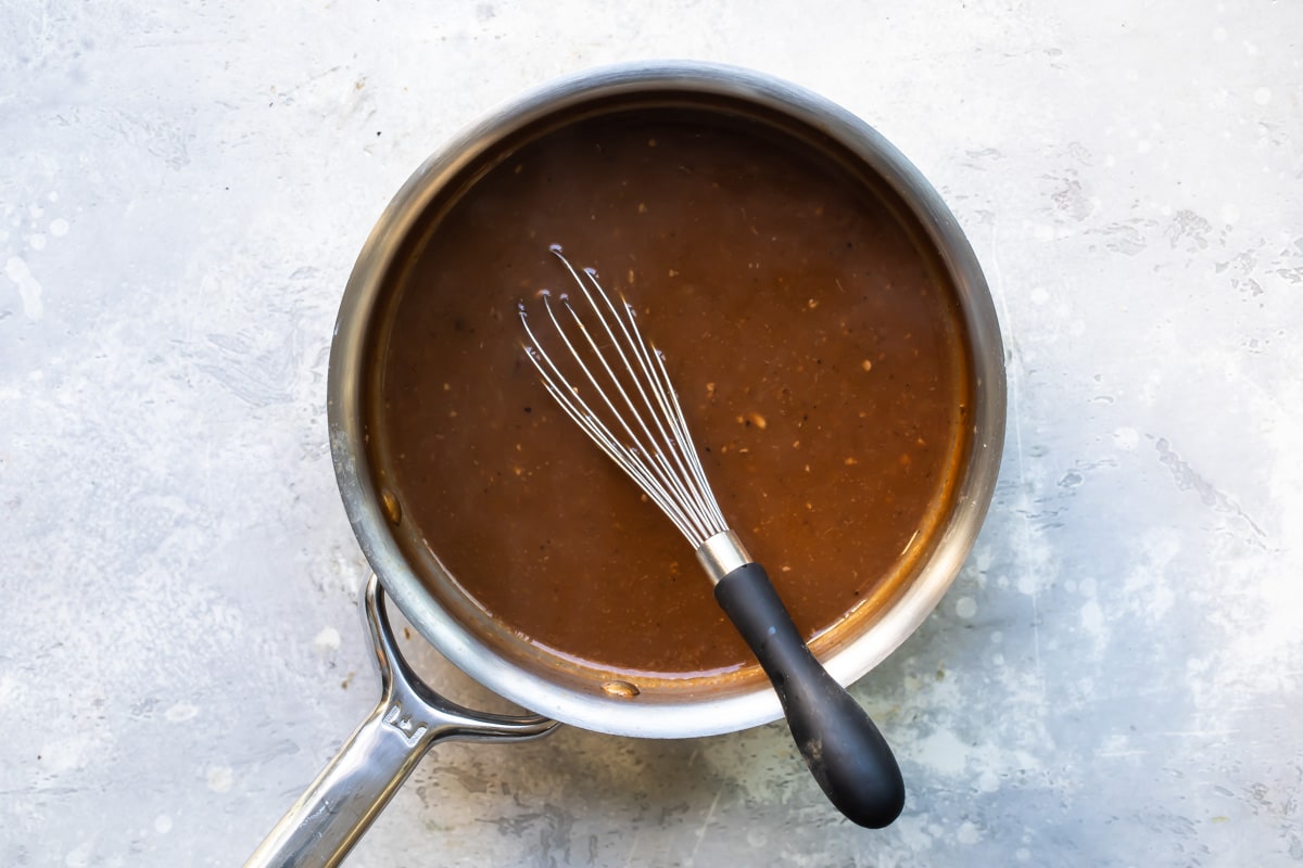 Pot roast gravy in a saucepan.