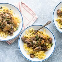 Steak tips with mushroom gravy in white bowls.