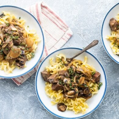 Steak tips with mushroom gravy in white bowls.