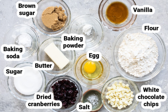 White chocolate chip cranberry cookie ingredients in bowls and labeled.