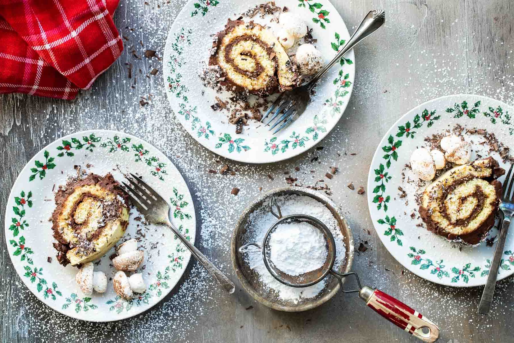 3 slices of Buche de Noel (yule log cake) on plates.