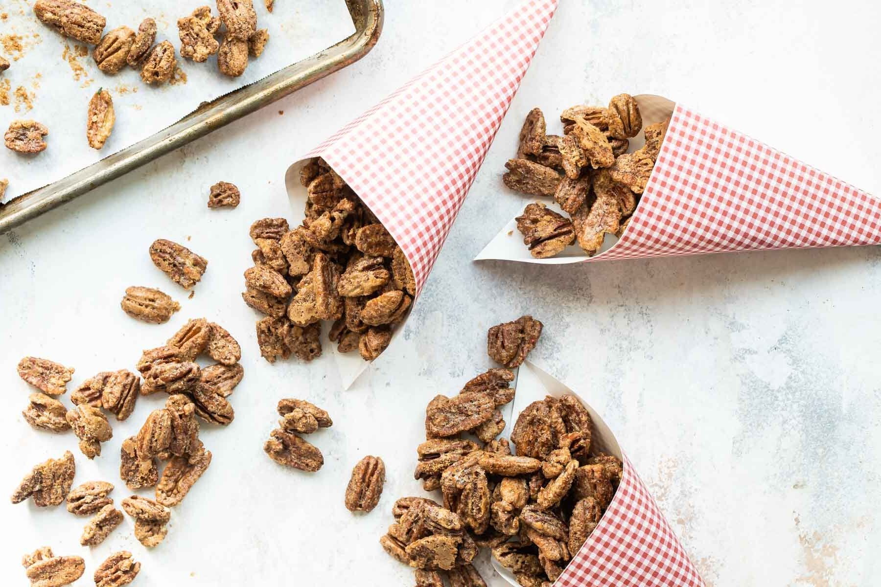 3 paper cones filled with candied pecans.