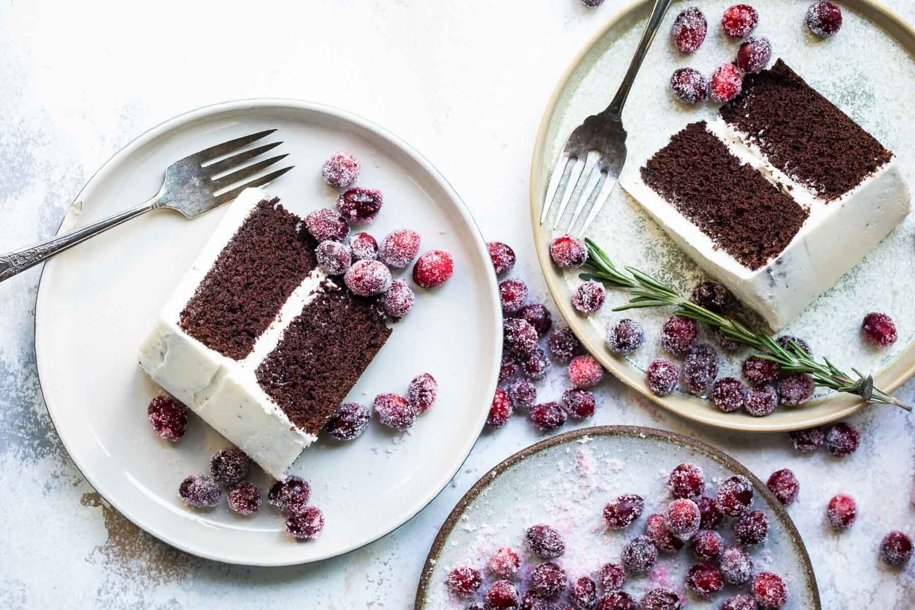 Two slices of cranberry wreath cake with sugared cranberries as a garnish.