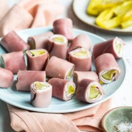 Ham roll ups on a light blue plate.