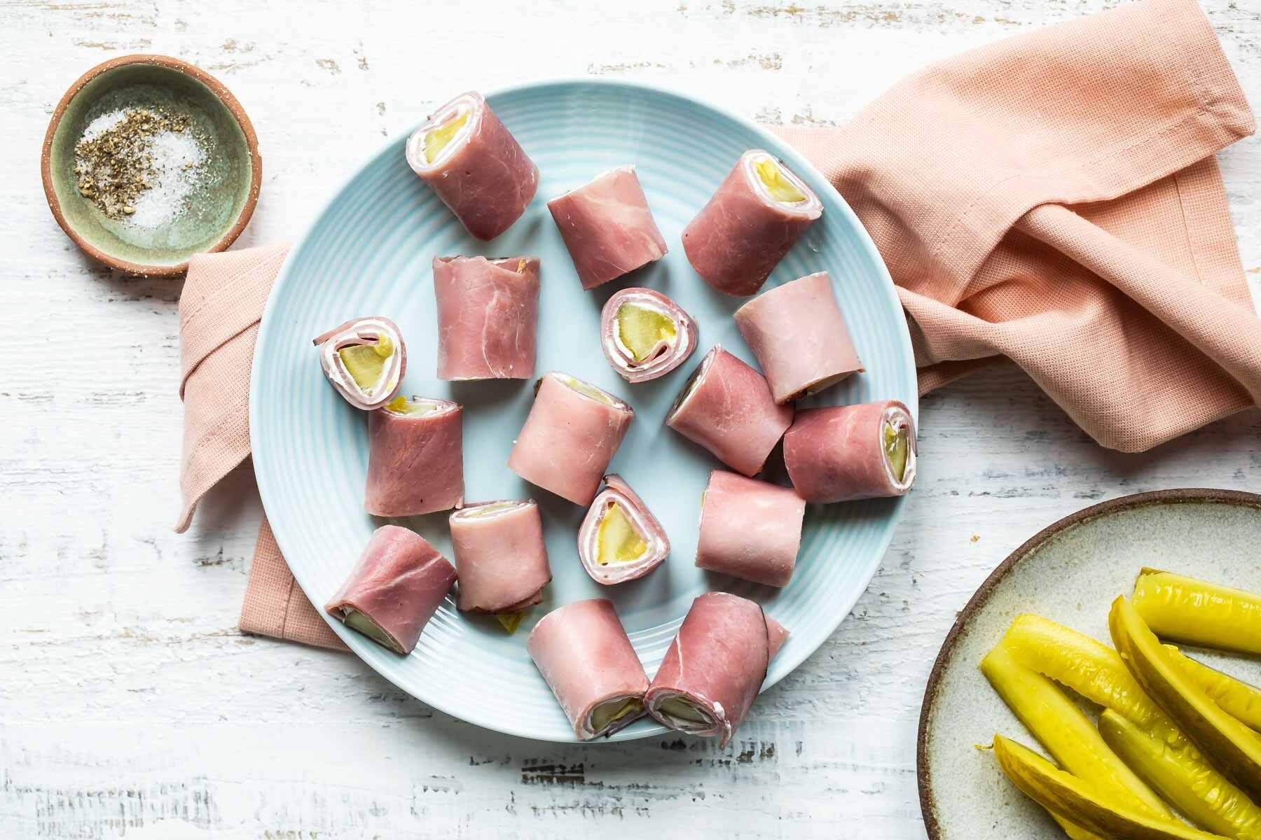 Ham roll ups on a light blue plate.