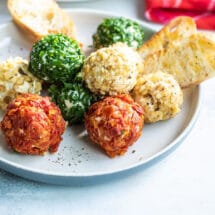 Mini cheese balls on a platter with crackers and crostini.
