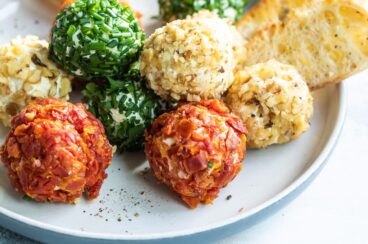 Mini cheese balls on a platter with crackers and crostini.
