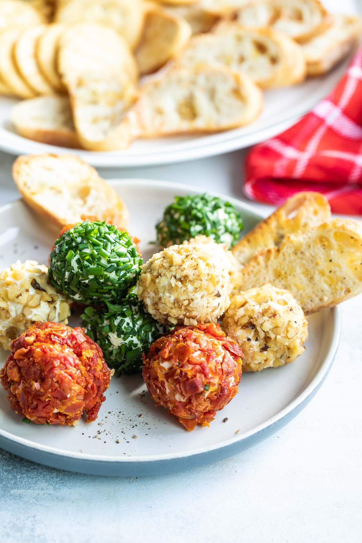 Mini cheese balls on a platter with crackers and crostini.