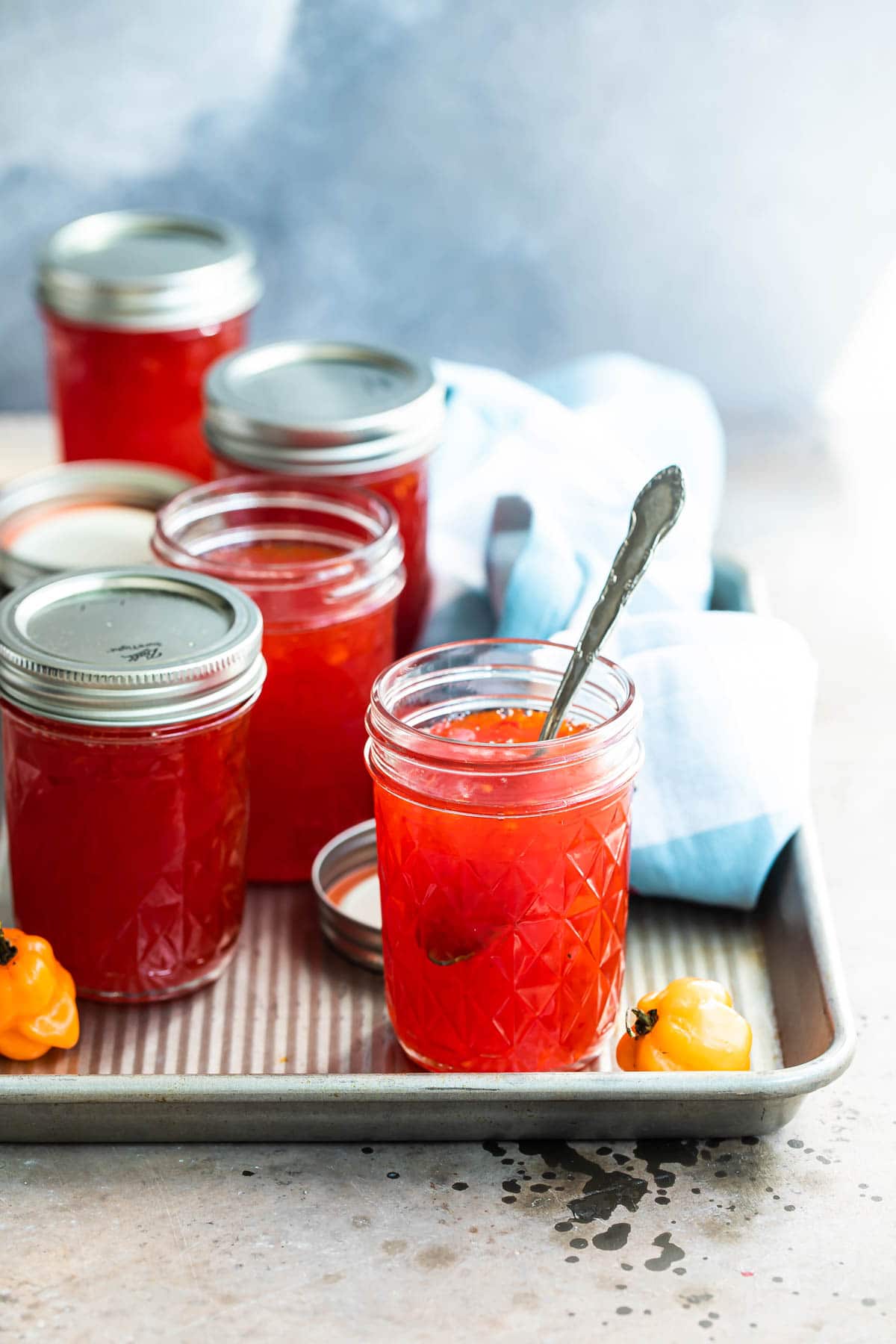 Jars of red pepper jelly on a tray.