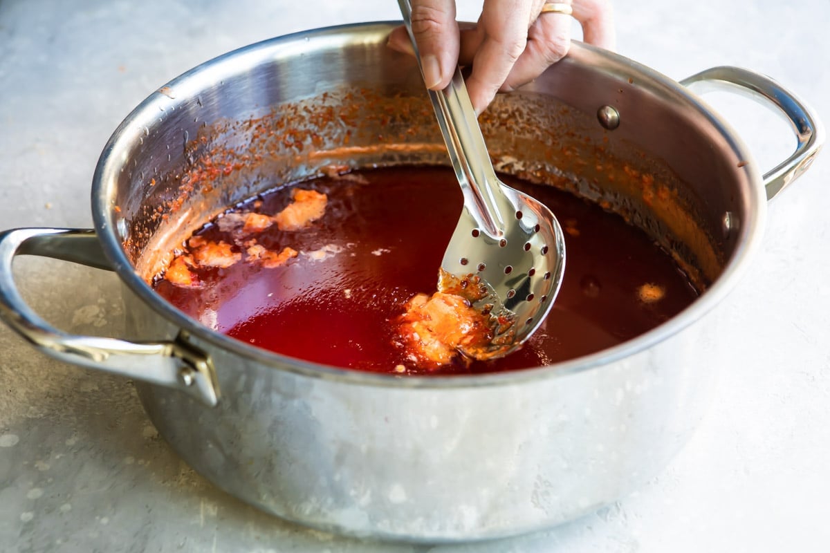 Skimming the foam off a pan of pepper jelly.