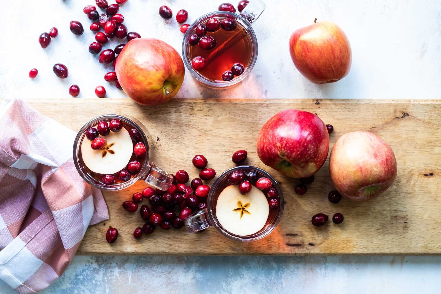 Slow cooker cranberry apple cider in a clear mug.