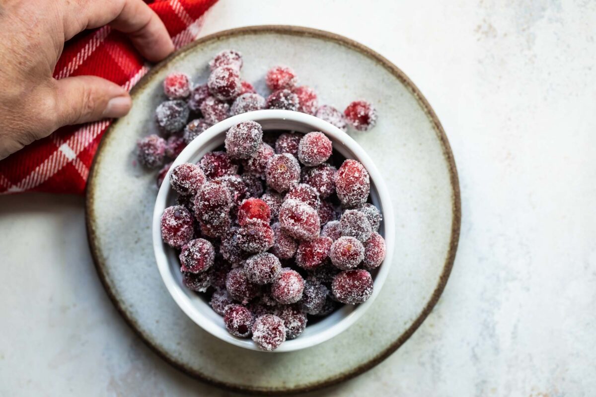 Sugared cranberries in a small white bowl.