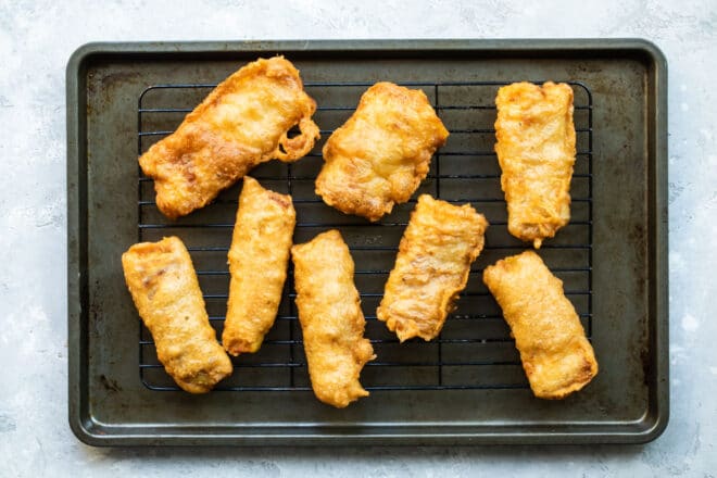 Beer battered cod on a baking sheet.