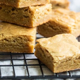 A stack of blondies on a cooling rack.