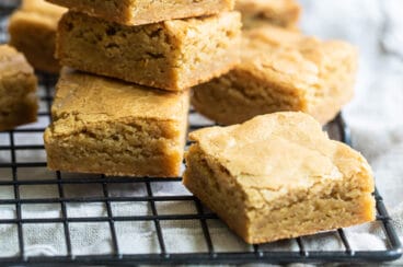 A stack of blondies on a cooling rack.