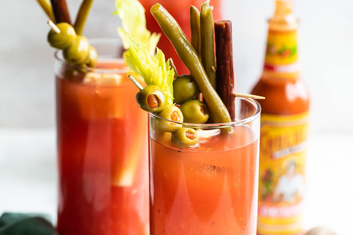 Two bloody marys with garnishes.