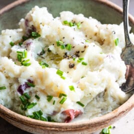 Boursin mashed potatoes in a light green bowl.