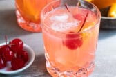 A brandy old fashioned in a clear glass.