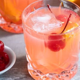 A brandy old fashioned in a clear glass.