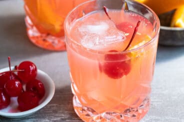 A brandy old fashioned in a clear glass.