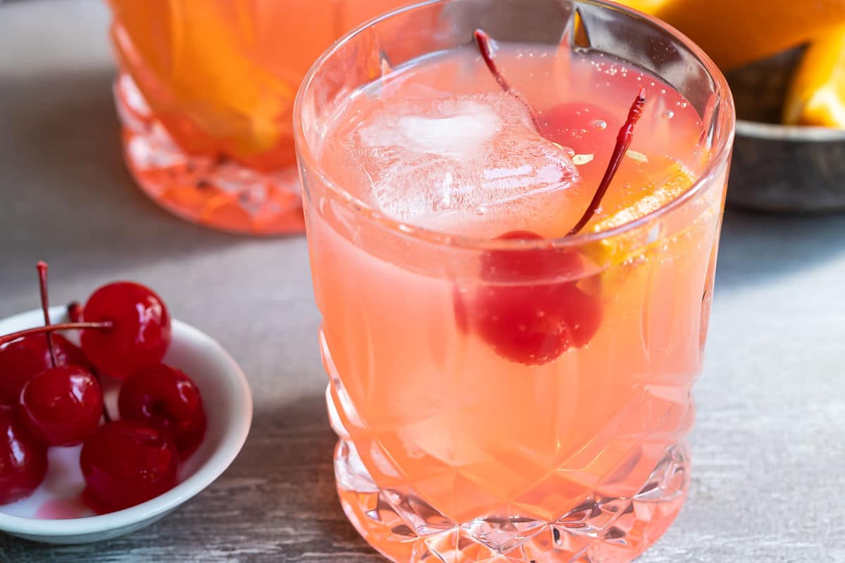 A brandy old fashioned in a clear glass.