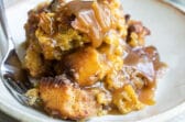 A plate of bread pudding with a fork resting on it.