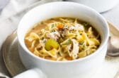 Chicken noodle soup in a white bowl.