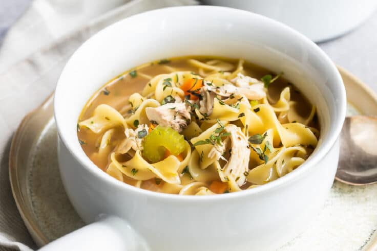 Chicken noodle soup in a white bowl.