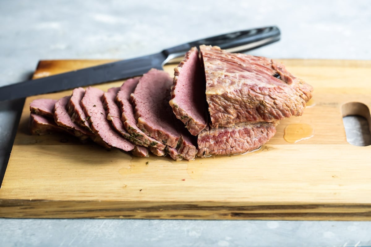 Corned beef sliced on a cutting board.