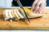 Carving roasted turkey breast into slices.