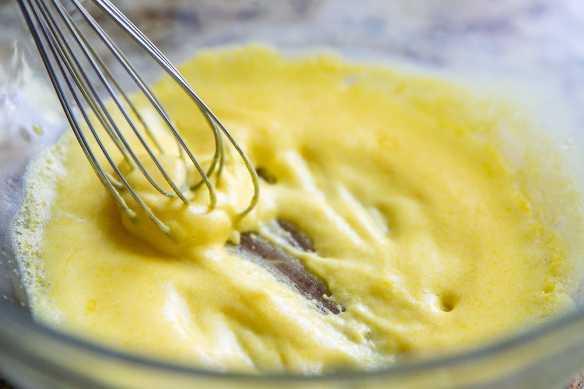 Making hollandaise sauce in a glass bowl.